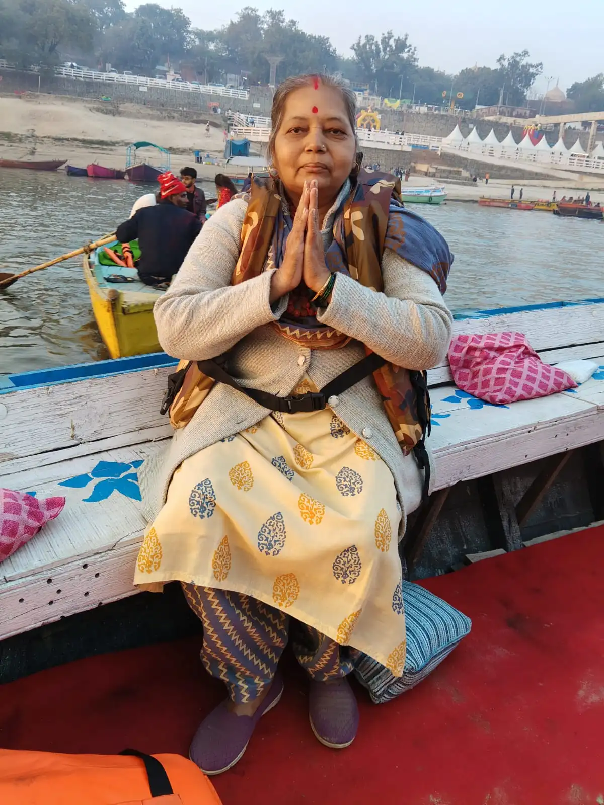 Guest offering prayers on a boat during evening Aarti
